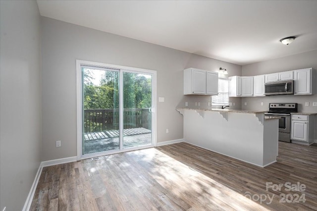 kitchen with plenty of natural light, white cabinetry, and stainless steel appliances