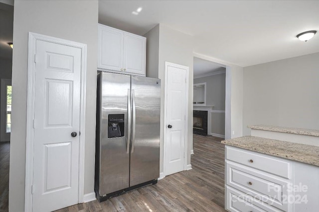 kitchen with light stone counters, dark hardwood / wood-style flooring, crown molding, white cabinetry, and stainless steel refrigerator with ice dispenser