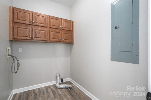 laundry area featuring electric panel, hookup for a washing machine, cabinets, and dark hardwood / wood-style flooring