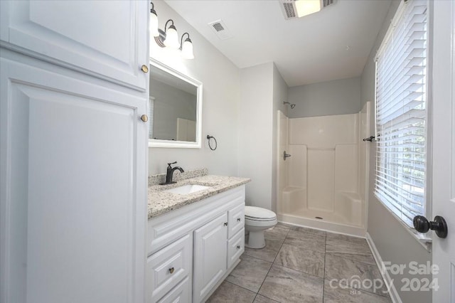 bathroom with walk in shower, vanity, toilet, and tile patterned floors