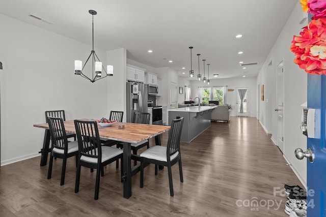 dining area with a notable chandelier and dark wood-type flooring