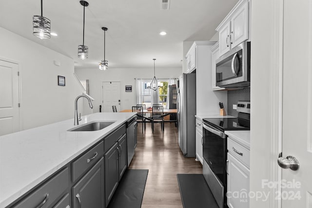kitchen with white cabinets, light countertops, a sink, and appliances with stainless steel finishes