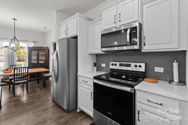 kitchen with stainless steel appliances, dark wood-type flooring, white cabinetry, an inviting chandelier, and backsplash