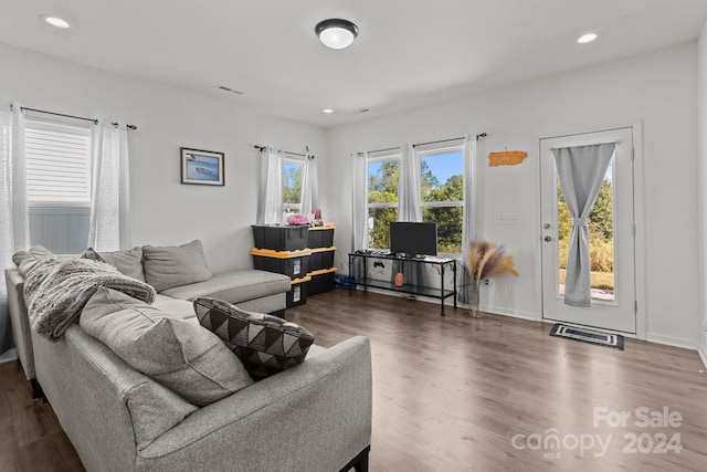 living area with recessed lighting, wood finished floors, visible vents, and baseboards