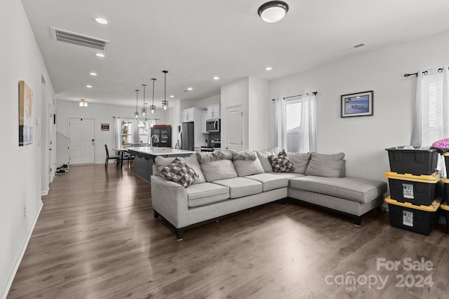 living room with dark wood-style floors, baseboards, visible vents, and recessed lighting