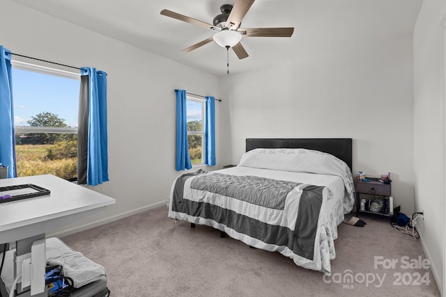 carpeted bedroom with ceiling fan and baseboards