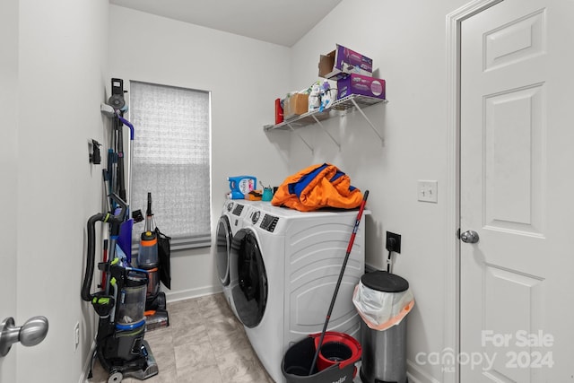 clothes washing area featuring washing machine and dryer, baseboards, and laundry area