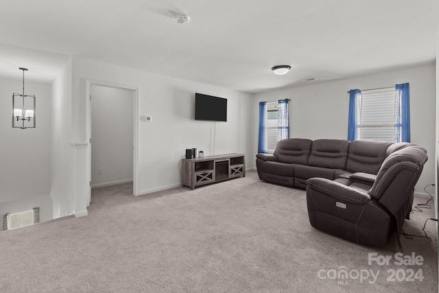 living room with light carpet and a chandelier