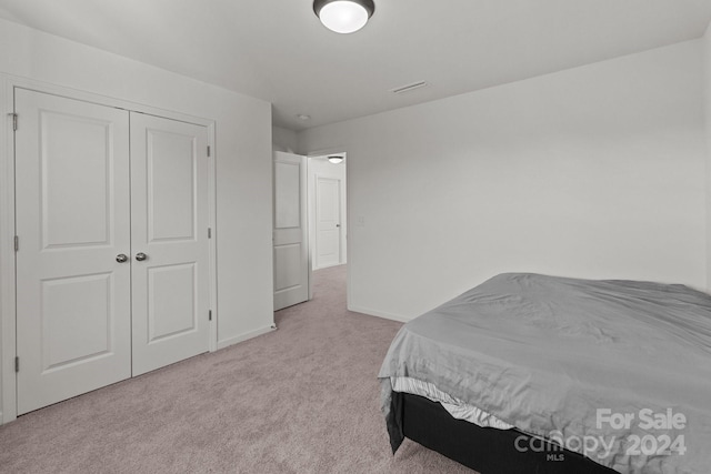 bedroom with a closet and light carpet