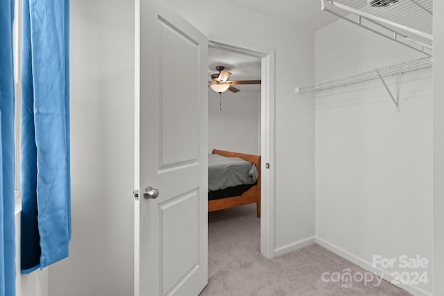 spacious closet featuring light colored carpet and ceiling fan