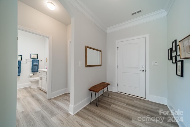 entrance foyer with ornamental molding and light hardwood / wood-style flooring