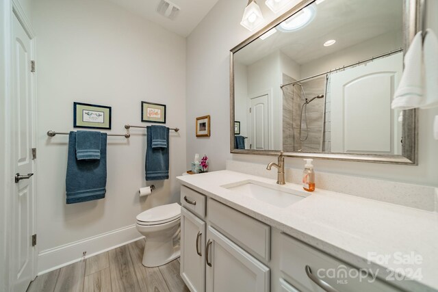 bathroom with vanity, curtained shower, wood-type flooring, and toilet