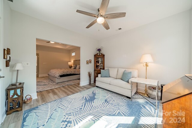 living room featuring light hardwood / wood-style floors and ceiling fan