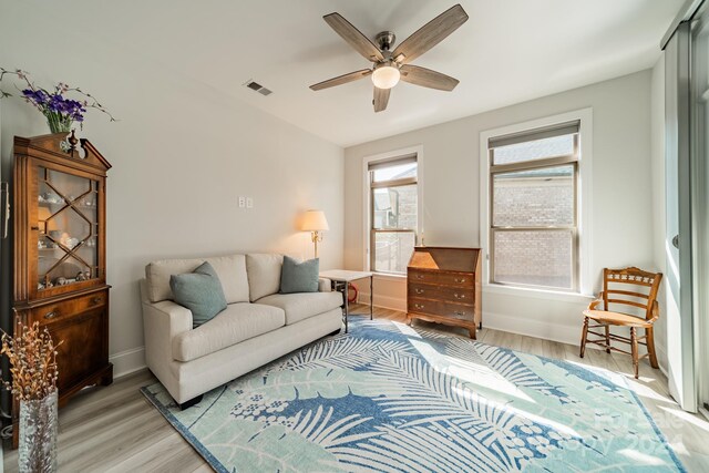 living room with light hardwood / wood-style floors and ceiling fan