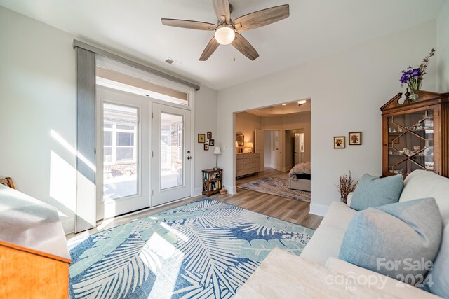 living room featuring wood-type flooring and ceiling fan