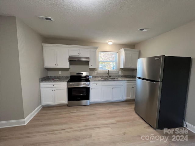 kitchen with white cabinetry, appliances with stainless steel finishes, sink, and light wood-type flooring