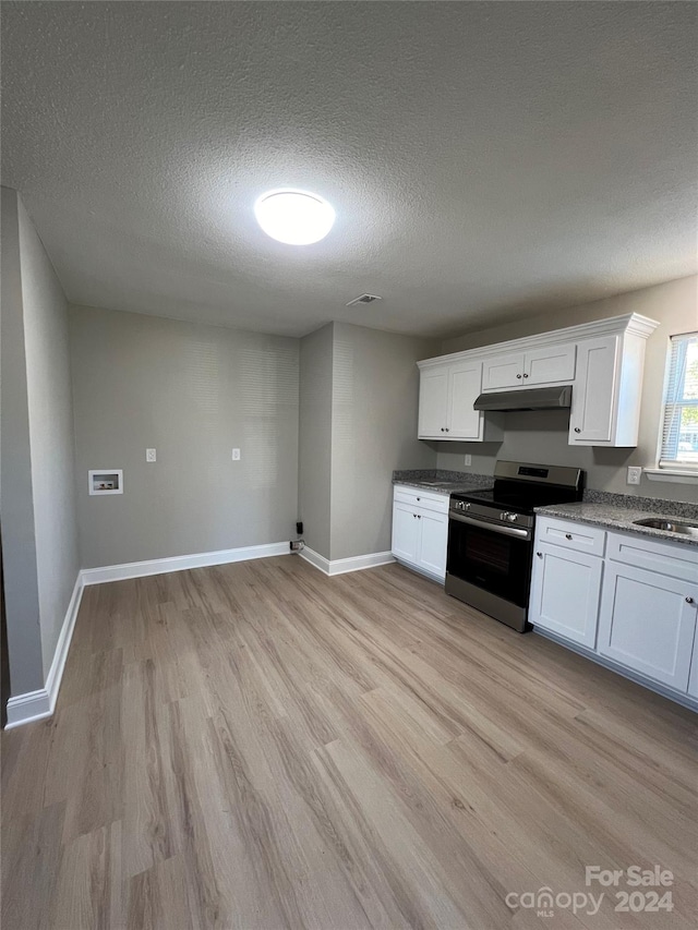 kitchen featuring stainless steel range, white cabinets, and light wood-type flooring