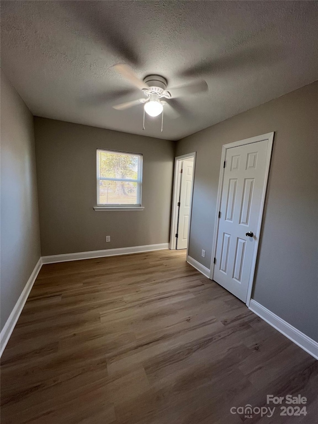 unfurnished bedroom featuring ceiling fan, a textured ceiling, and light wood-type flooring