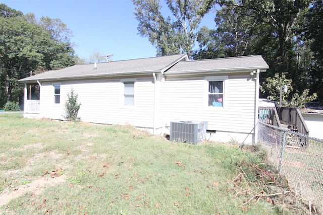 view of side of home with central AC unit and a lawn