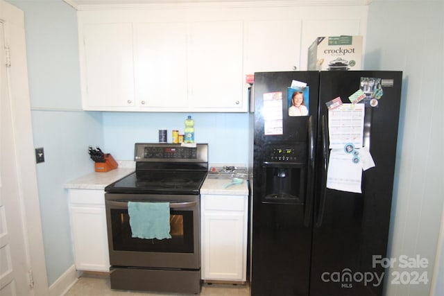 kitchen with black fridge, stainless steel range with electric stovetop, and white cabinetry