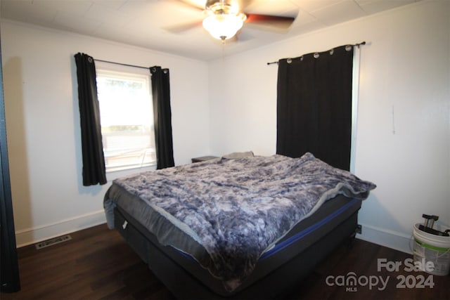 bedroom featuring crown molding, dark hardwood / wood-style flooring, and ceiling fan