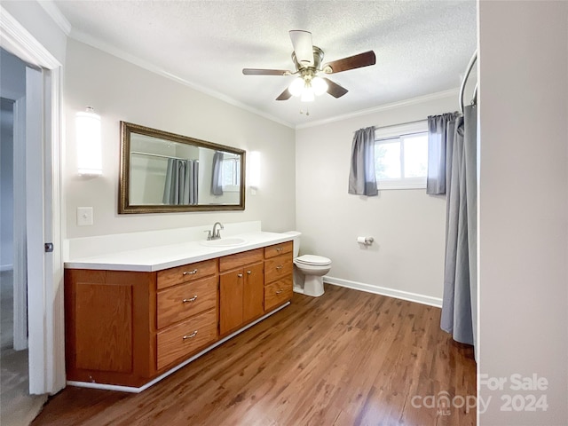 bathroom with vanity, hardwood / wood-style flooring, ornamental molding, toilet, and a textured ceiling