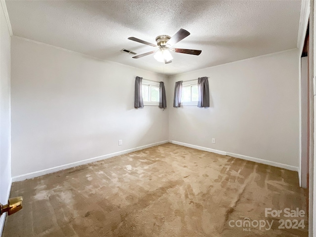 carpeted spare room with a textured ceiling and ceiling fan