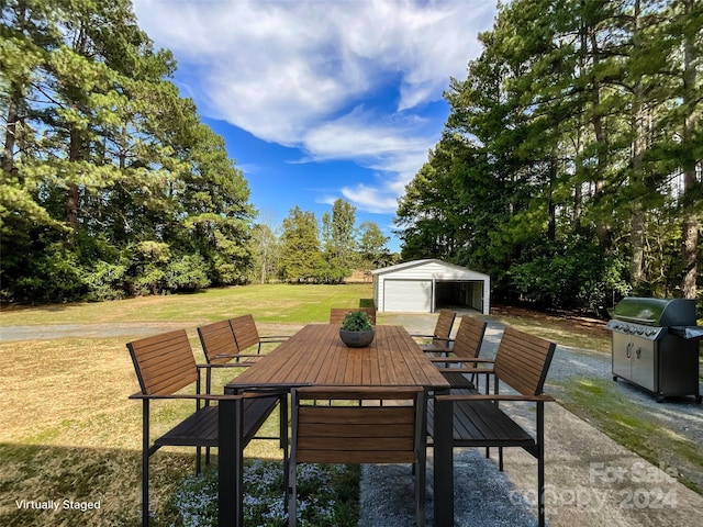 view of patio featuring a garage, area for grilling, and an outdoor structure