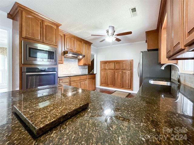 kitchen with stainless steel appliances, crown molding, sink, and decorative backsplash