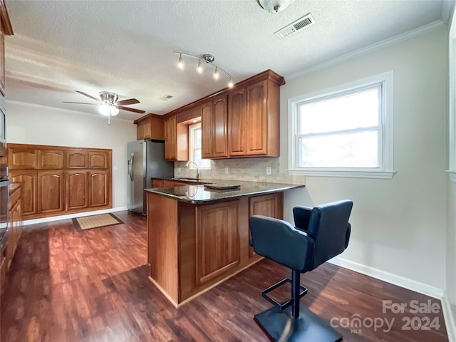 kitchen with stainless steel fridge, ceiling fan, kitchen peninsula, dark hardwood / wood-style floors, and a textured ceiling