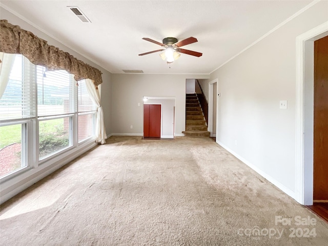 empty room with ornamental molding, light carpet, and ceiling fan