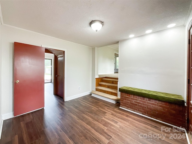 unfurnished room with ornamental molding, dark hardwood / wood-style flooring, and a textured ceiling