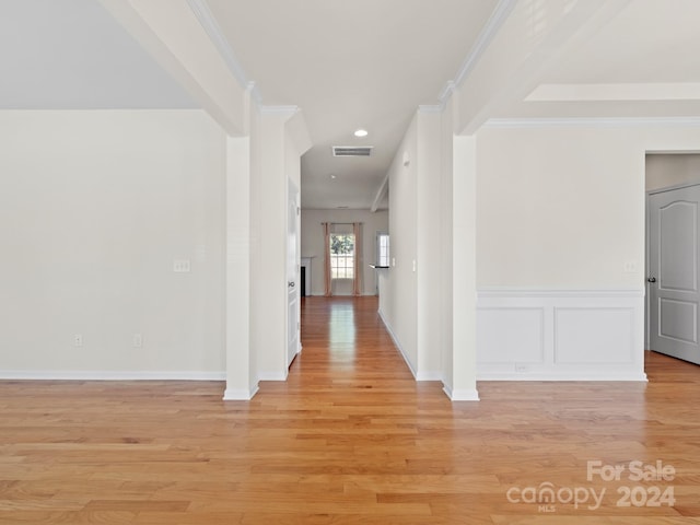 hallway featuring ornamental molding and light hardwood / wood-style floors