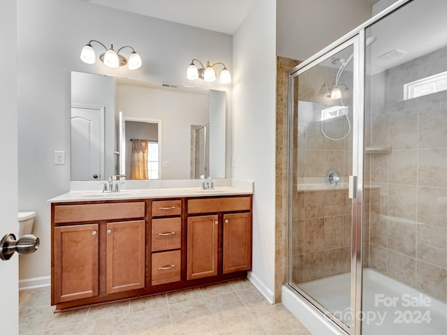 bathroom with vanity, toilet, tile patterned flooring, and an enclosed shower