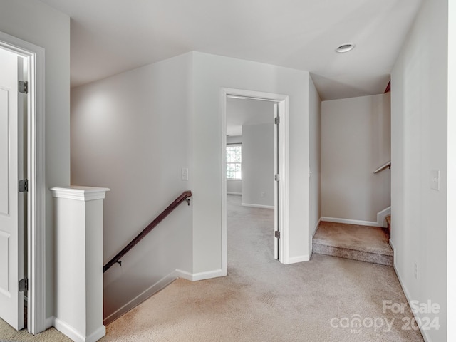 hall with light colored carpet