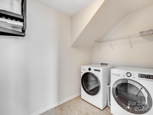 laundry area featuring washer and clothes dryer and light tile patterned floors