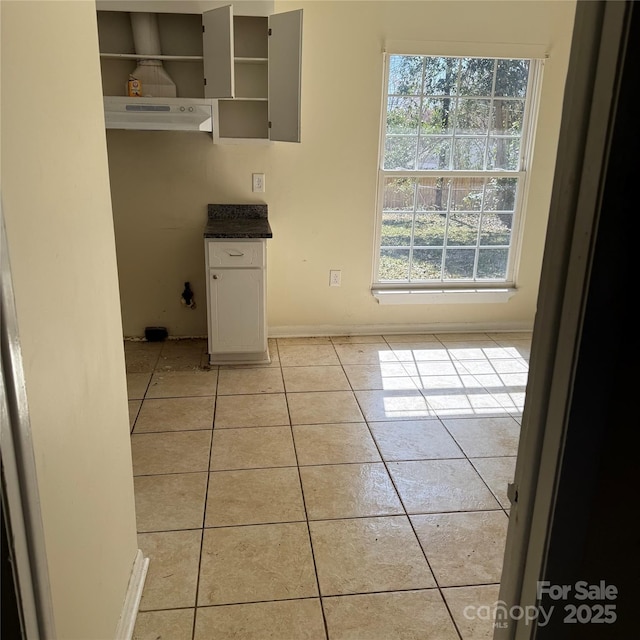 unfurnished dining area featuring light tile patterned floors and baseboards