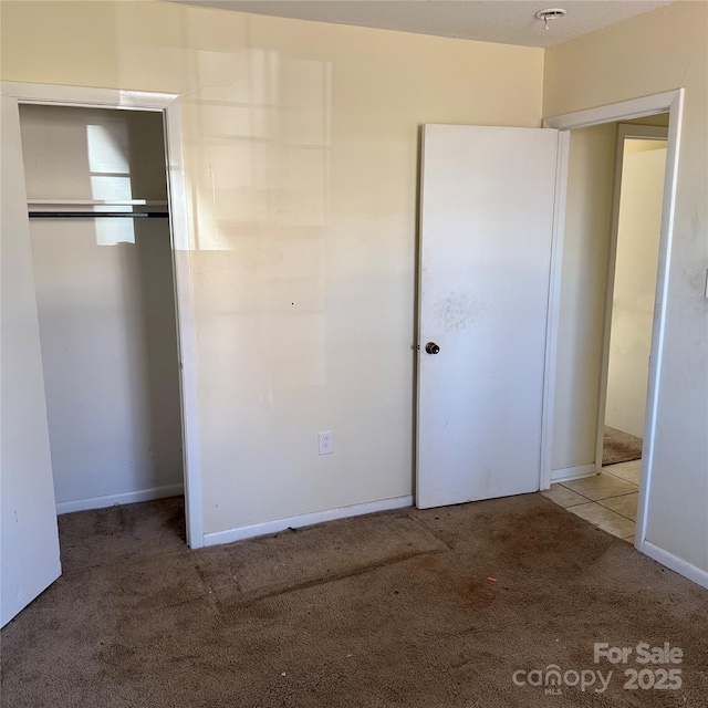 unfurnished bedroom featuring a closet and carpet flooring