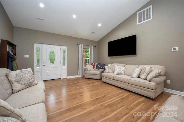 living room featuring light hardwood / wood-style floors and vaulted ceiling