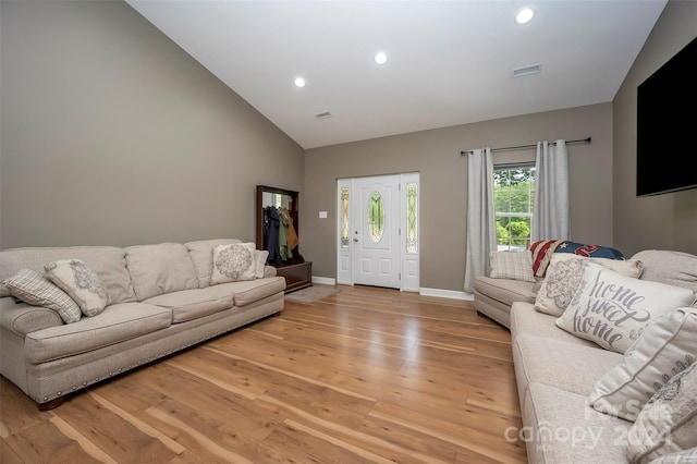 living room with vaulted ceiling and light wood-type flooring