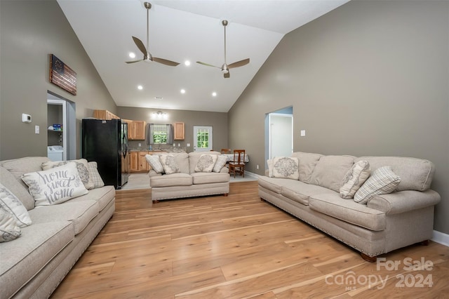 living room featuring ceiling fan, sink, high vaulted ceiling, and light hardwood / wood-style flooring