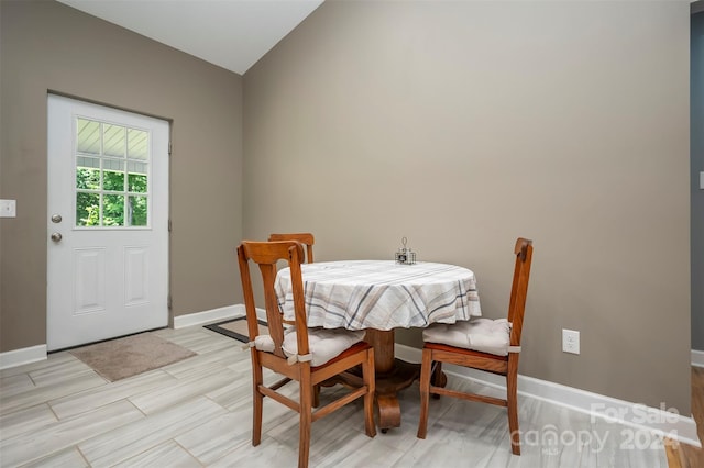 dining space featuring light hardwood / wood-style flooring and vaulted ceiling