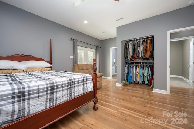 bedroom with ceiling fan, wood-type flooring, french doors, and a closet