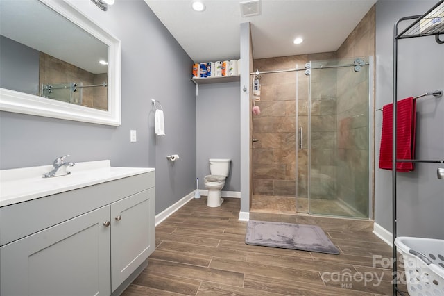 bathroom featuring wood-type flooring, vanity, toilet, and an enclosed shower