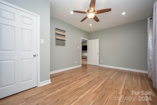 unfurnished bedroom with ceiling fan and light hardwood / wood-style flooring