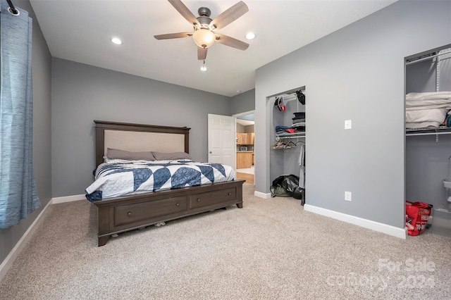 bedroom with ceiling fan, light colored carpet, and a closet