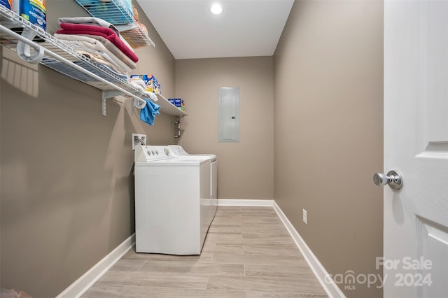 laundry area featuring electric panel, light hardwood / wood-style flooring, and independent washer and dryer