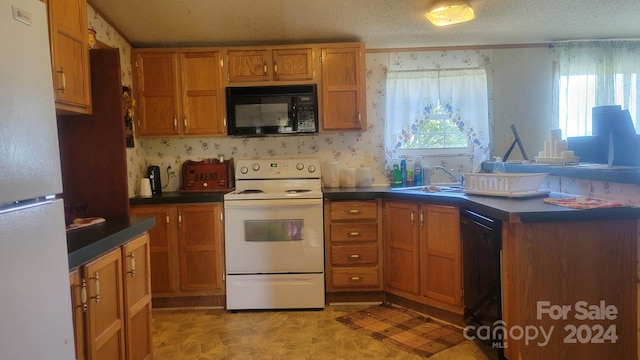 kitchen with black appliances, sink, and a textured ceiling