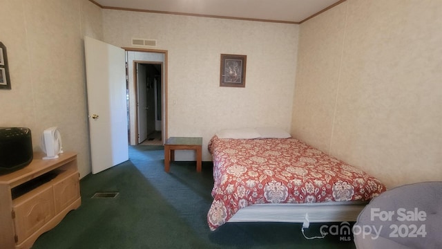 bedroom with crown molding and dark carpet