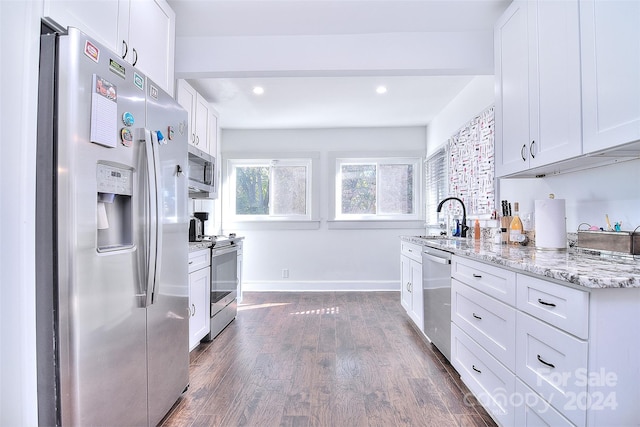 kitchen featuring dark wood-type flooring, stainless steel appliances, sink, light stone countertops, and white cabinetry